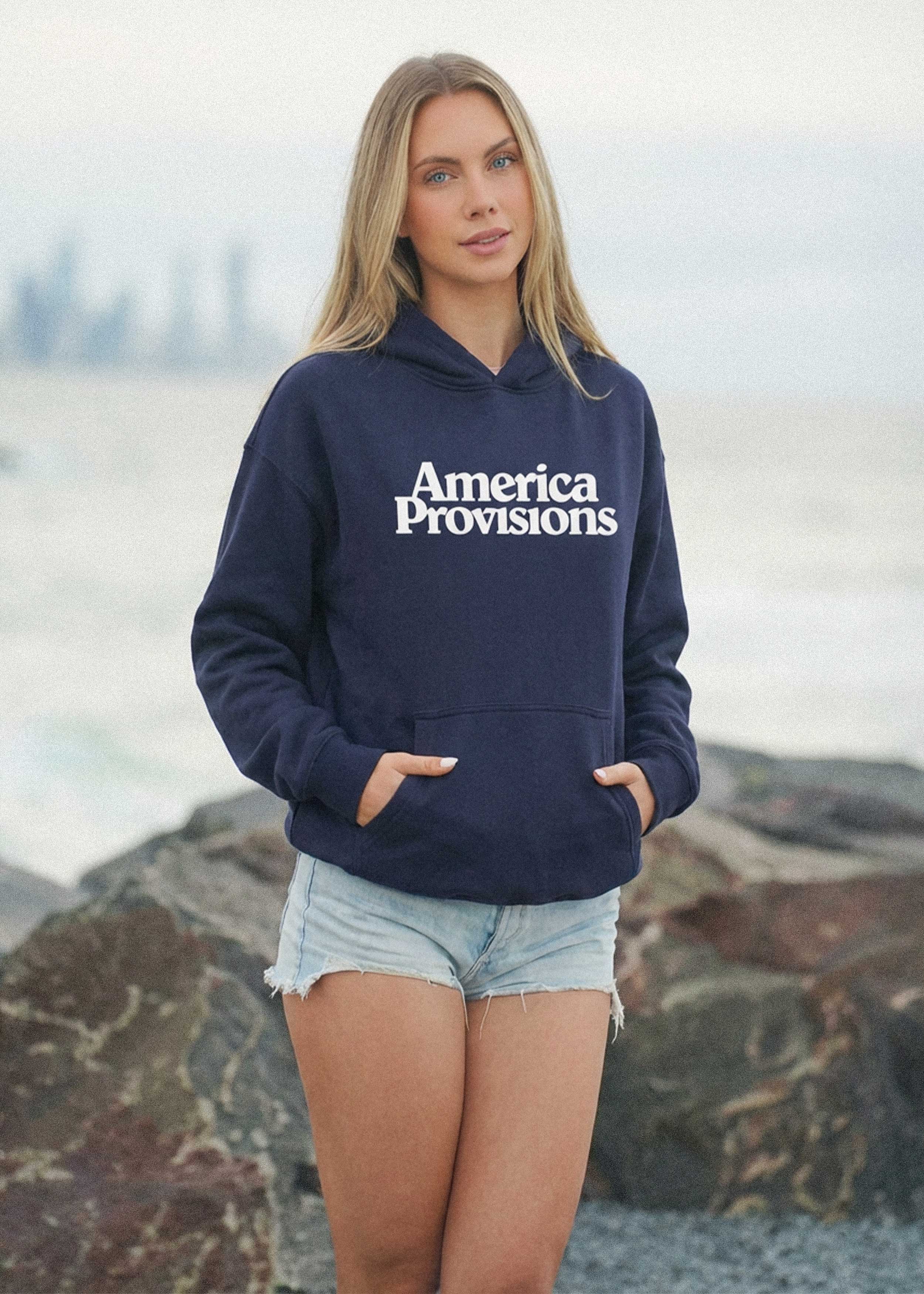 Model wearing Ink Blue America Provisions Logo Female relaxed graphic hoodie printed and shipped from the USA
