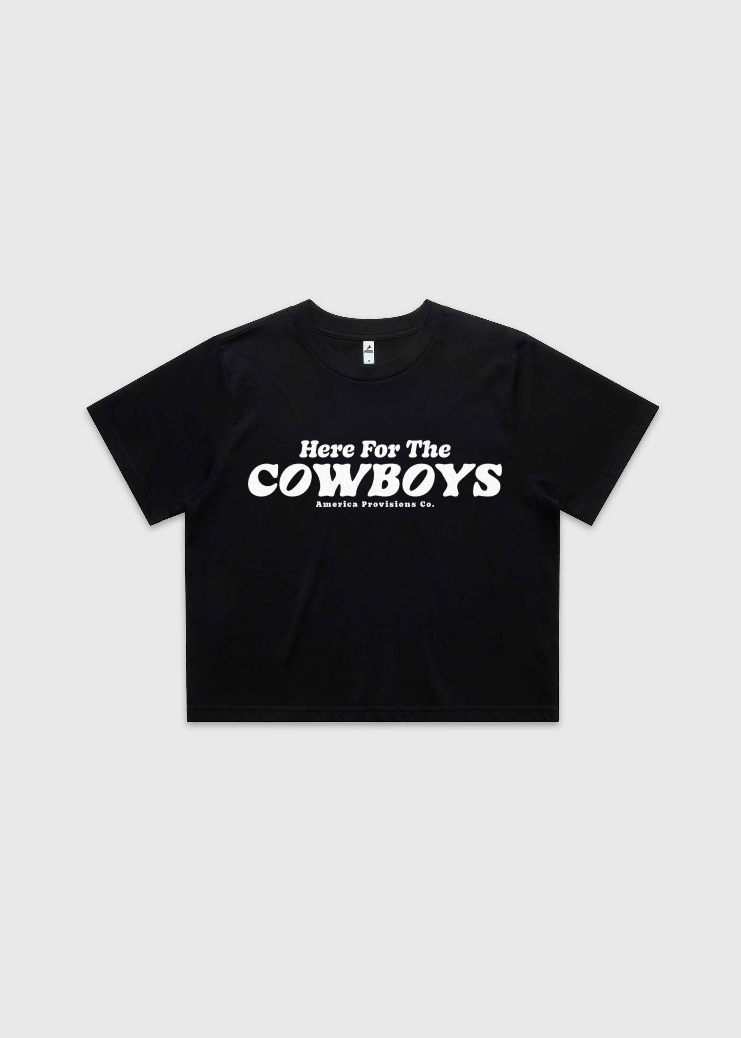 Black cropped t-shirt with bold red “Here For The Cowboys” Western graphic, structured boxy fit, heavy cotton fabric, America Provisions apparel product photo on a neutral background.