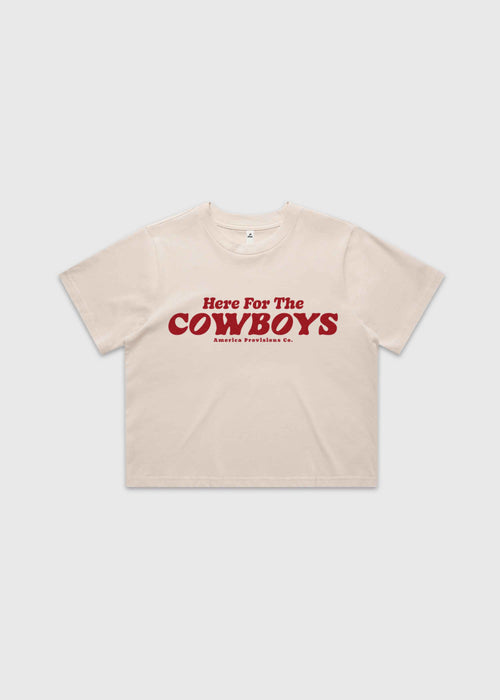Bone cropped t-shirt with bold red “Here For The Cowboys” Western graphic, structured boxy fit, heavy cotton fabric, America Provisions apparel product photo on a neutral background.