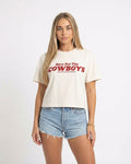 Model wearing ecru colored cropped t-shirt with bold red “Here For The Cowboys” Western graphic, structured boxy fit, heavy cotton fabric, America Provisions apparel product photo on a neutral background.