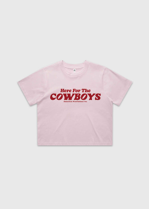 Pink cropped t-shirt with bold red “Here For The Cowboys” Western graphic, structured boxy fit, heavy cotton fabric, America Provisions apparel product photo on a neutral background.