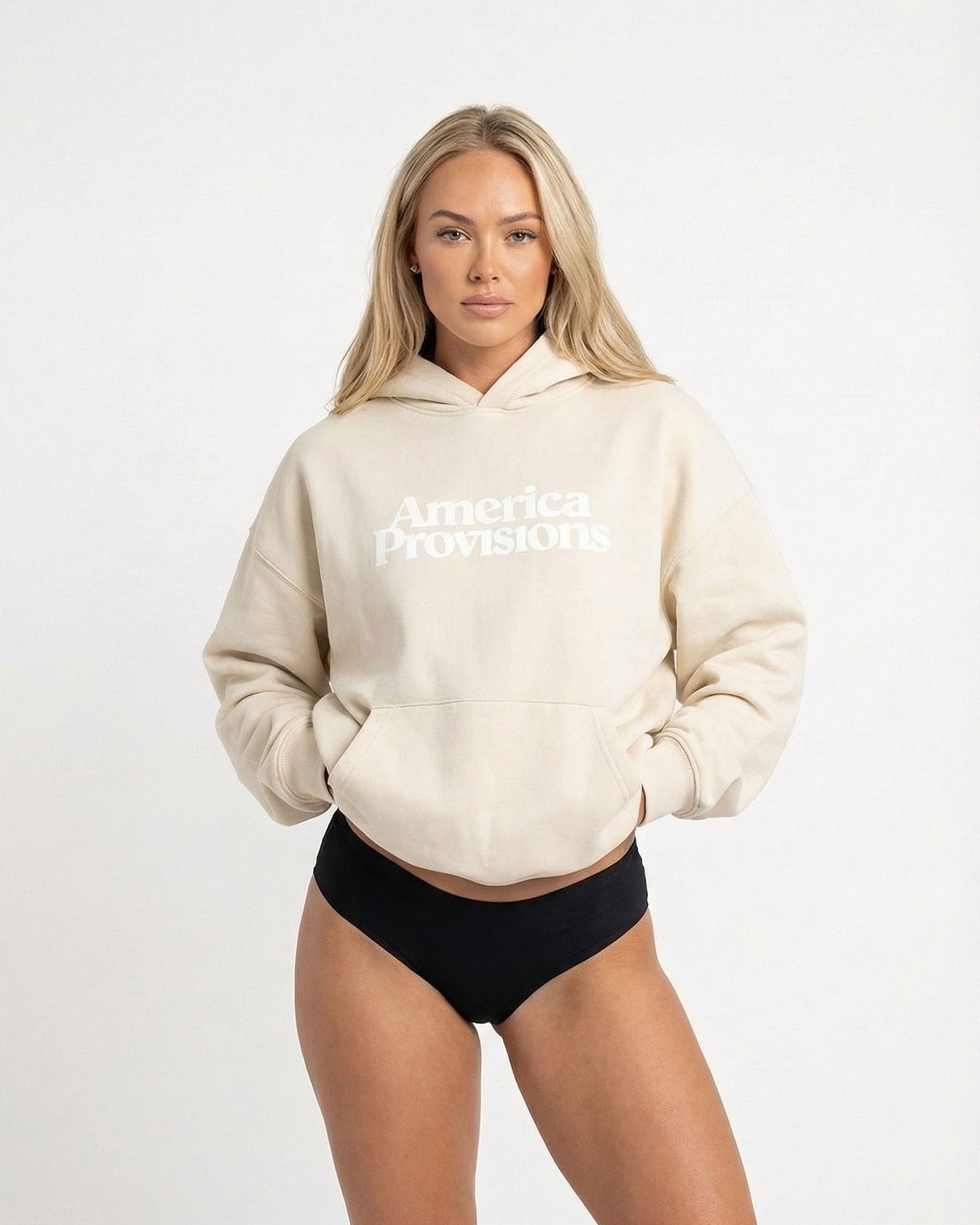 Woman wearing a Ecru coloured hoodie with 'America Provisions' text on a white background