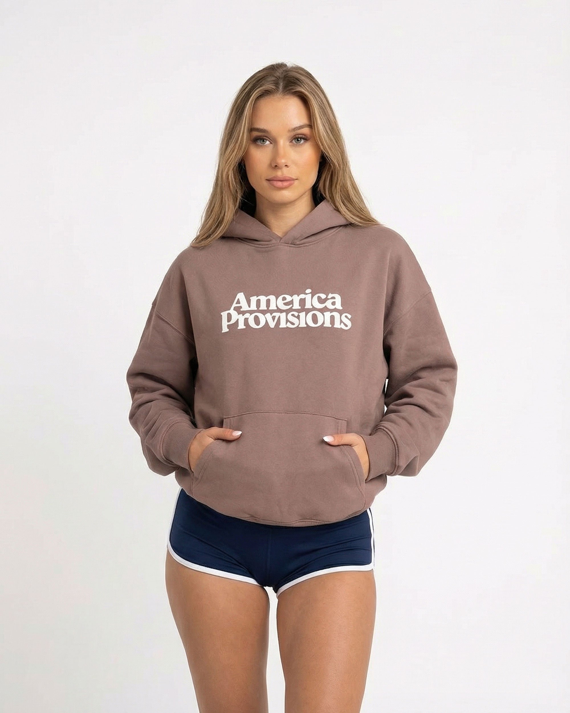 Woman wearing a Hazy Pink 'America Provisions' hoodie on a white background
