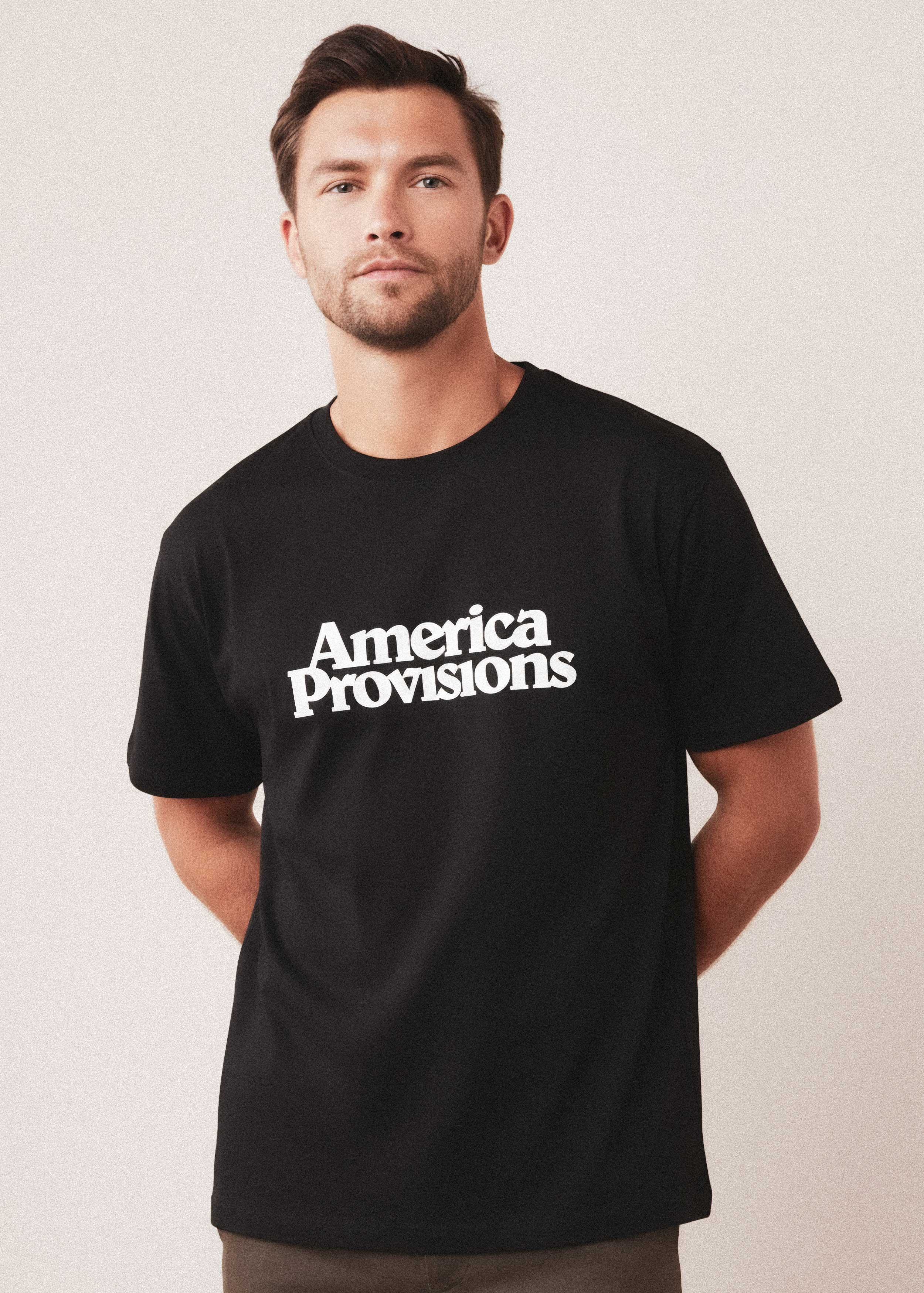 Man wearing a black t-shirt with 'America Provisions' text on a plain background