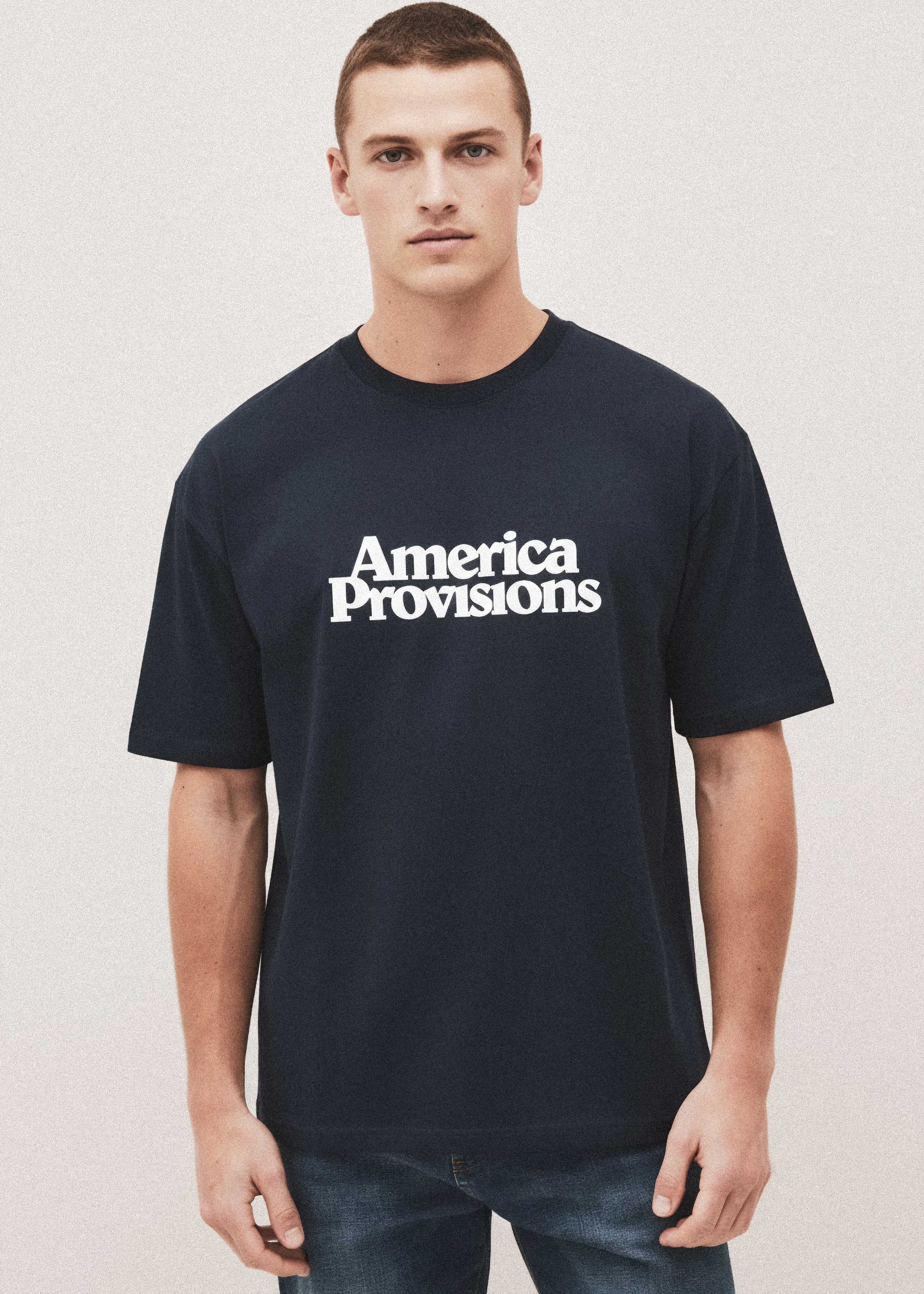 Man wearing a black t-shirt with 'America Provisions' text on a light background