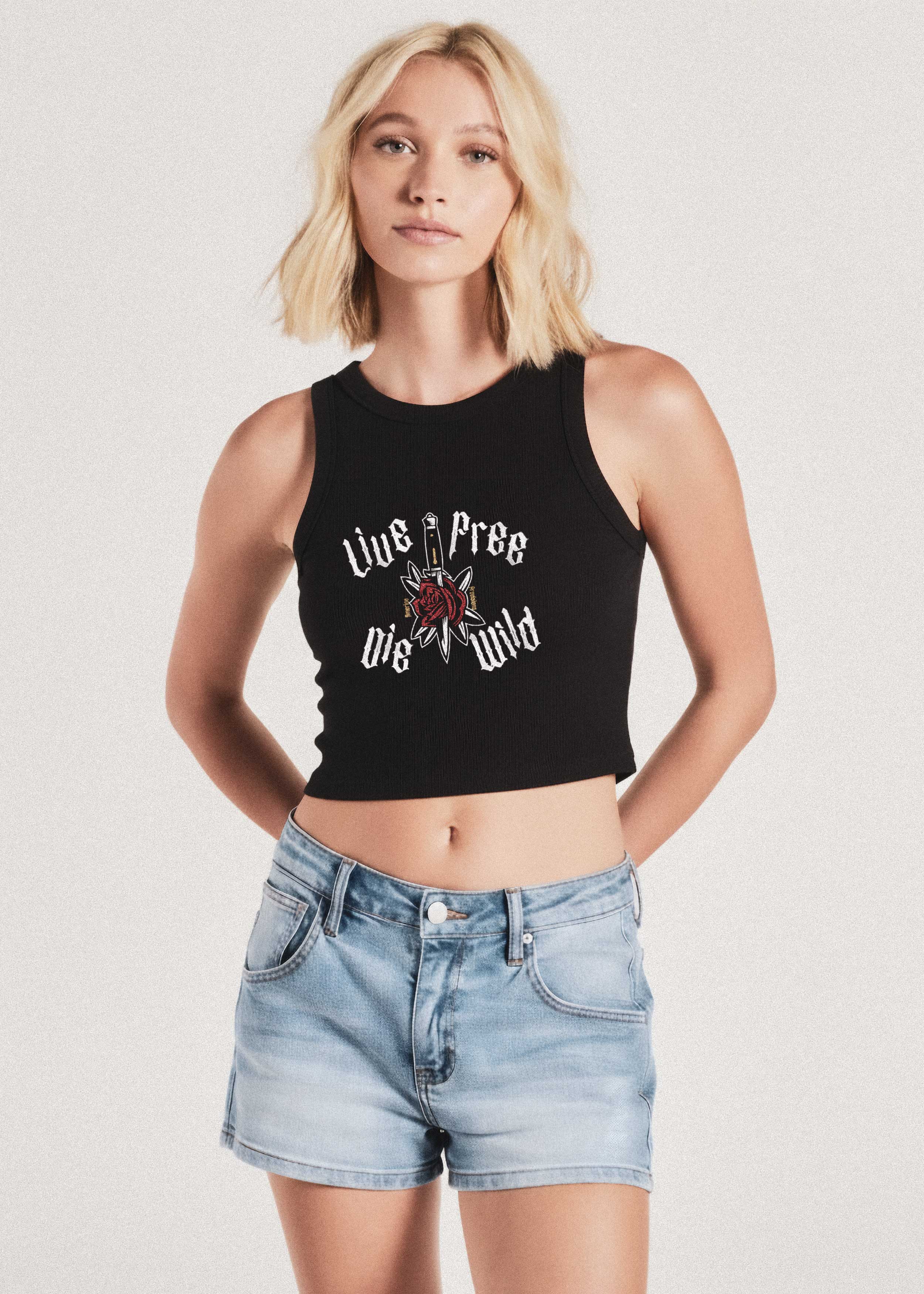 Woman wearing Live Free Die Wild black tank top, standing against a plain background