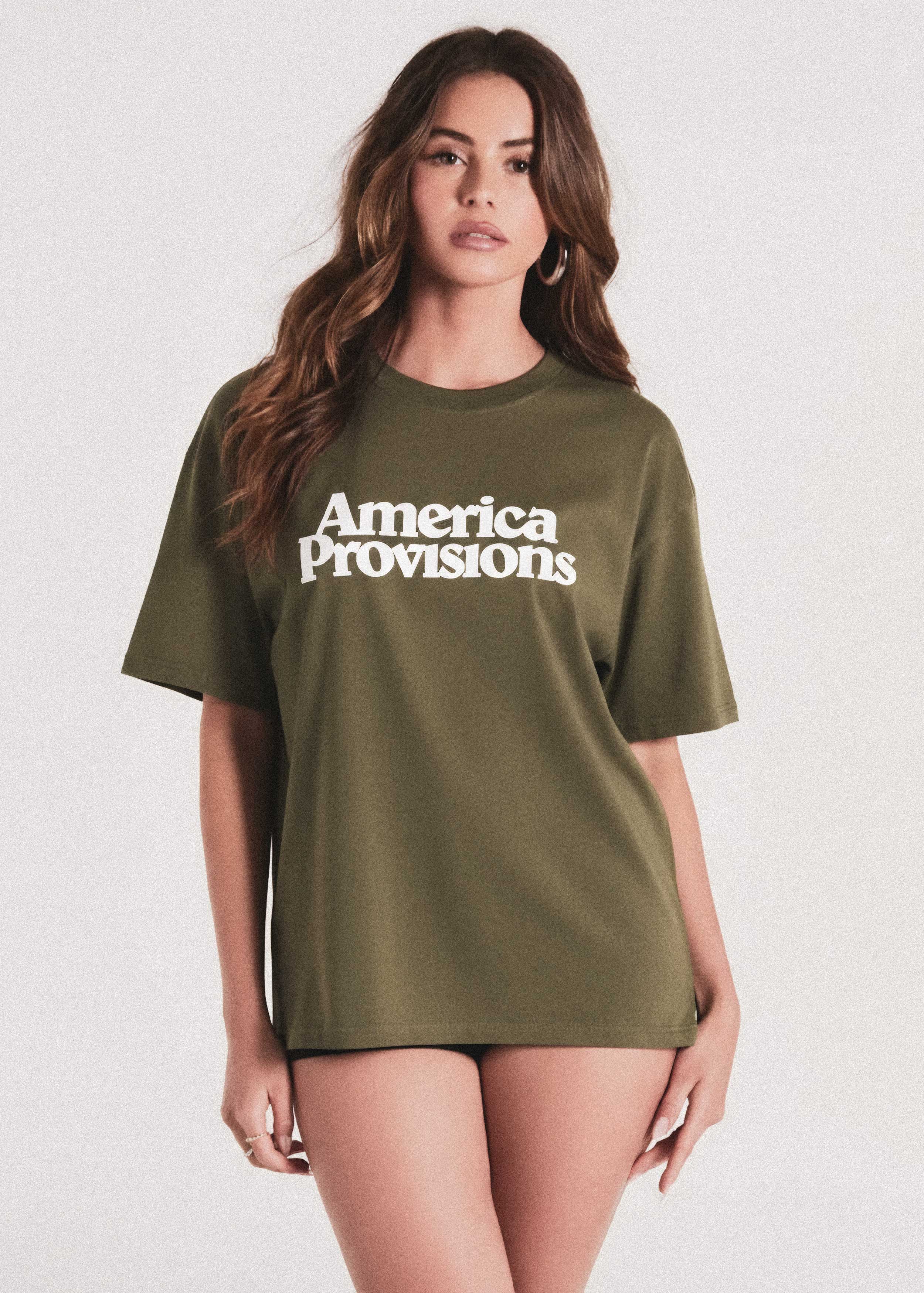 Woman wearing a green t-shirt with 'America Provisions' text on a white background