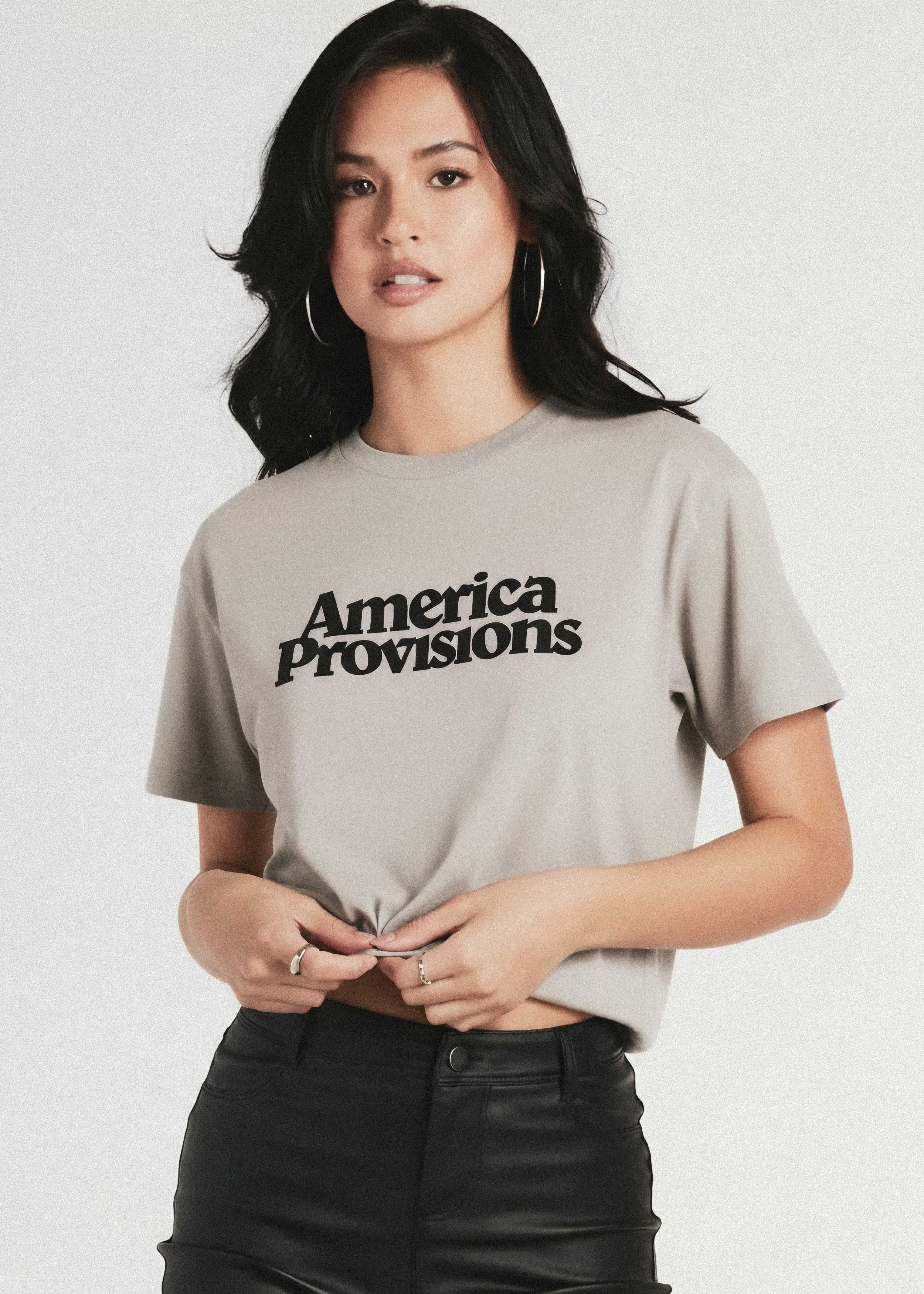 Woman wearing a gray t-shirt with 'America Provisions' text on a white background