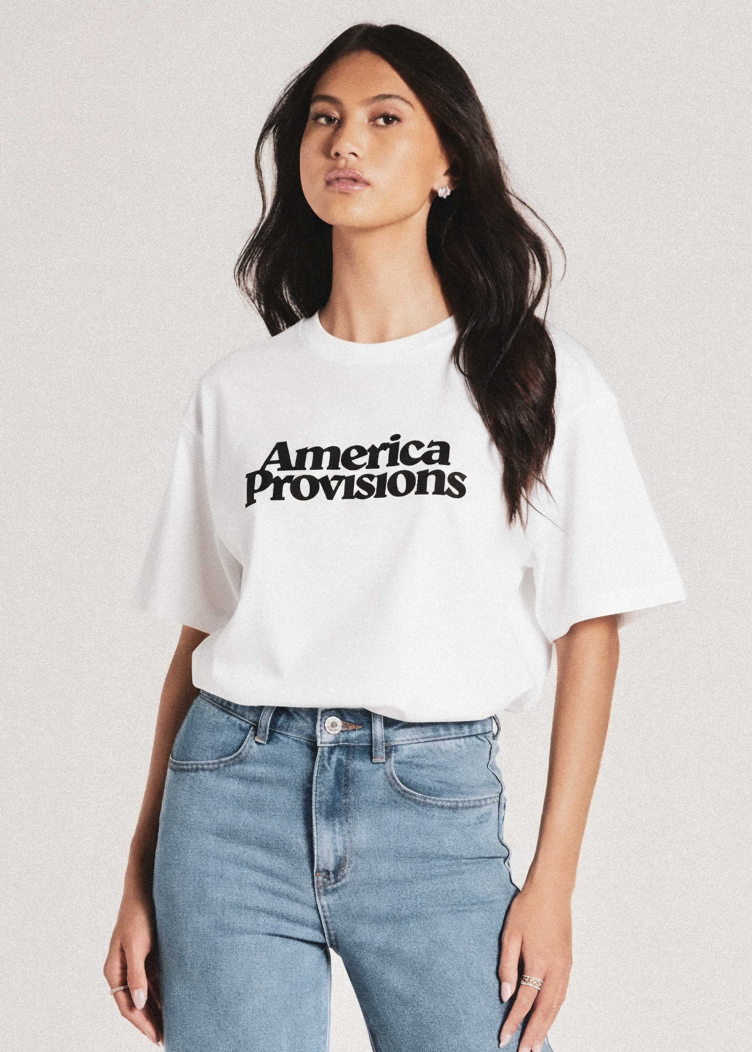 Person wearing a white t-shirt with 'America Provisions' text on a plain background
