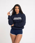 Woman wearing a navy blue hoodie with 'America Provisions' text on a white background
