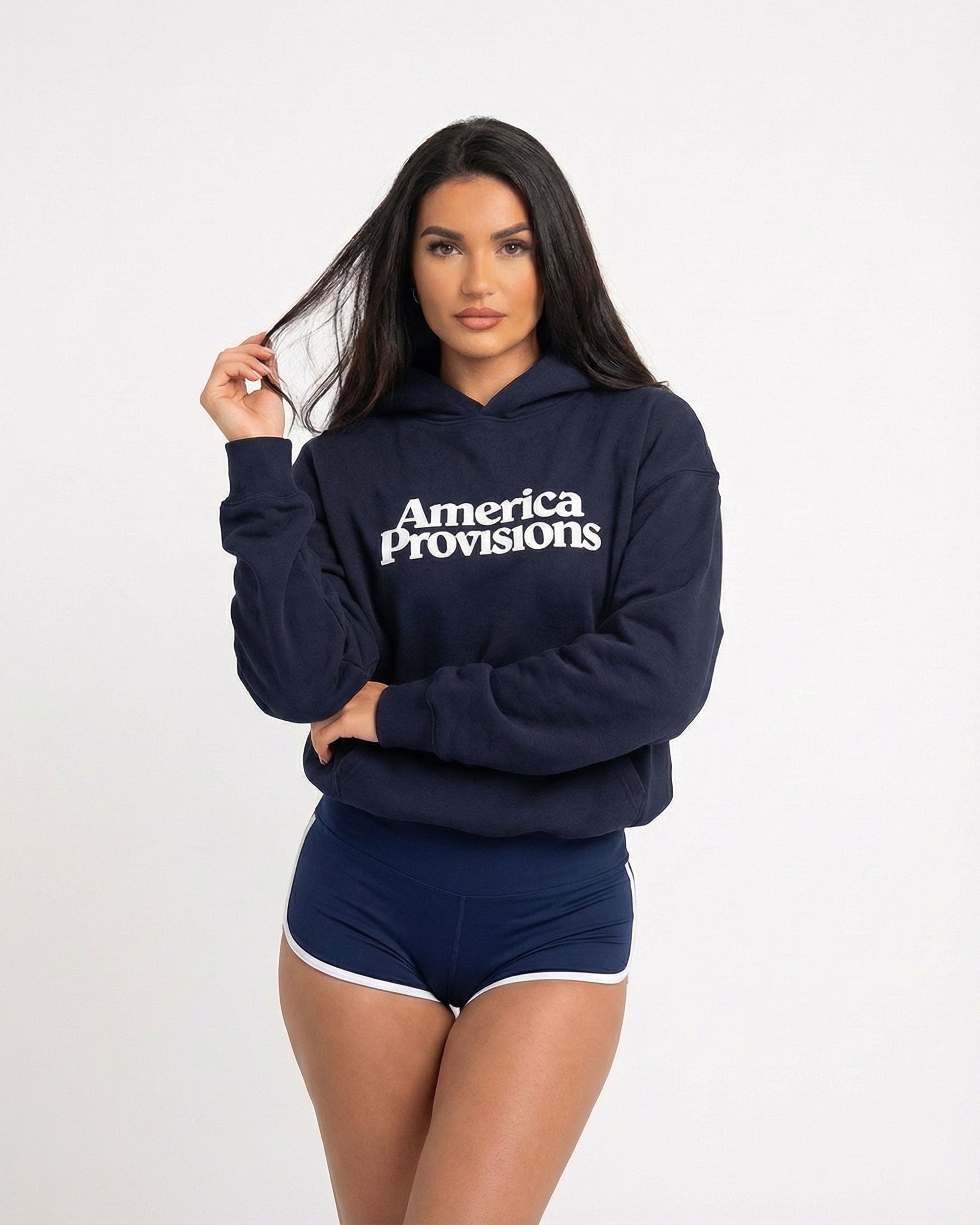 Woman wearing a navy blue hoodie with 'America Provisions' text on a white background