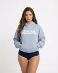 Woman wearing a Powder Blue hoodie with 'America Provisions' text on a white background