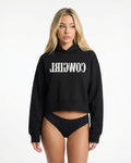 Reverse Cowgirl Woman wearing a cropped black hoodie with 'COWIRL' text on a white background