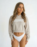 Reverse Cowgirl Woman wearing a cropped Bone colored hoodie with 'COWIRL' text on a white background