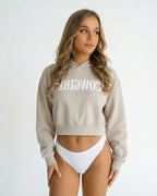 Reverse Cowgirl Woman wearing a cropped Bone colored hoodie with 'COWIRL' text on a white background