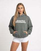 Woman wearing a Gray hoodie with 'America Provisions' text on a white background