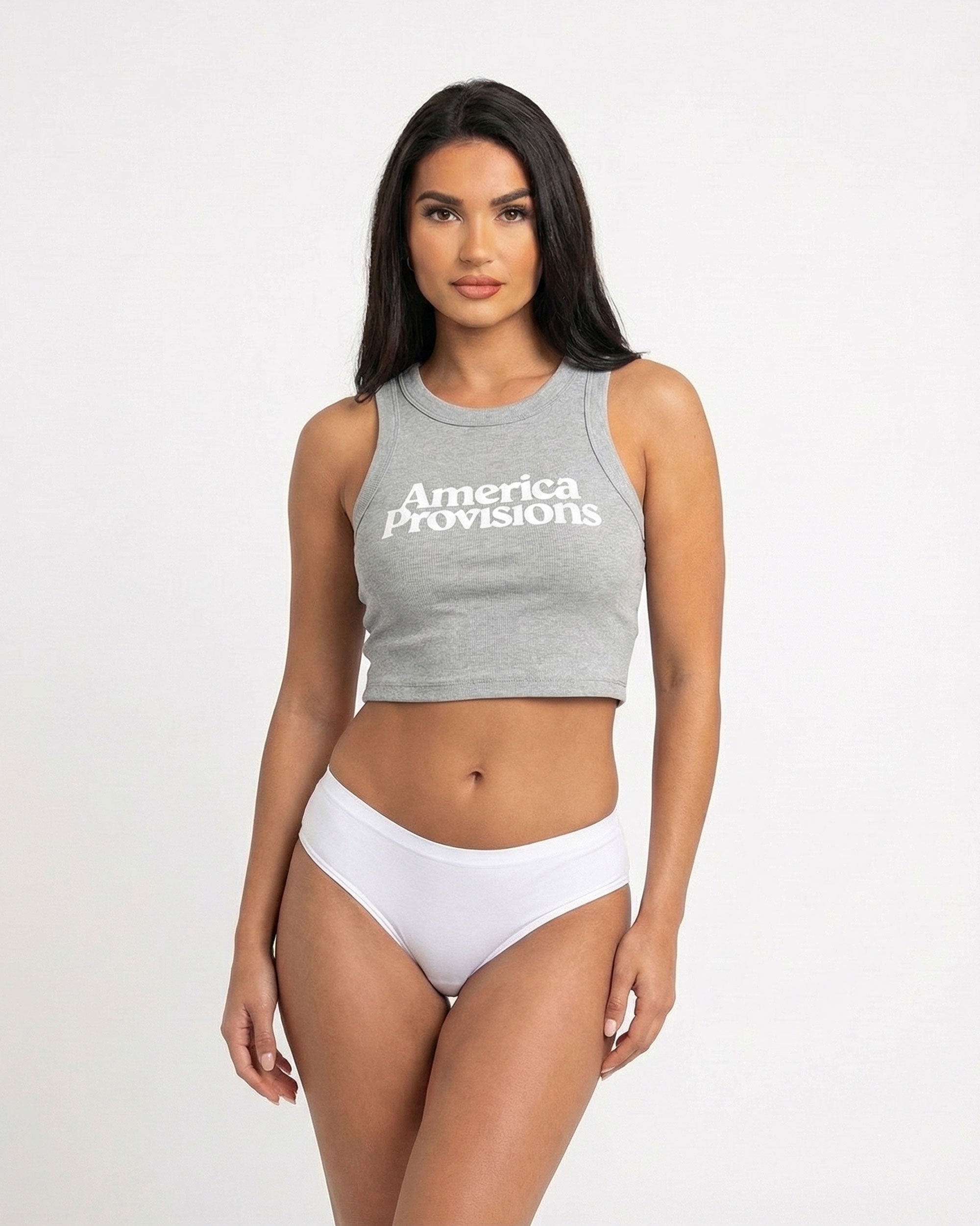 Storm gray crop top with America Provisions logo on. Blonde model is wearing the crop top and denim shorts