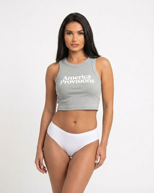 Storm gray crop top with America Provisions logo on. Blonde model is wearing the crop top and denim shorts